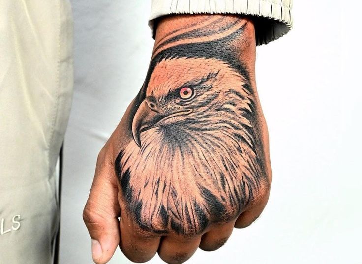 a man's hand with an eagle tattoo on it