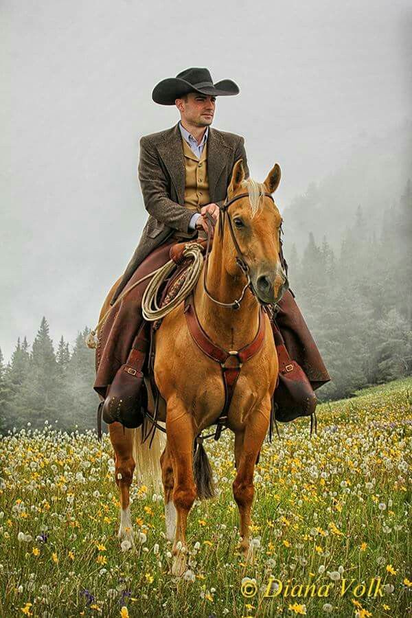 a man riding on the back of a brown horse in a field full of flowers