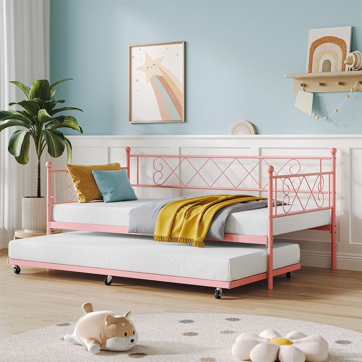 a pink daybed in a blue bedroom with white rugs and pillows on the floor