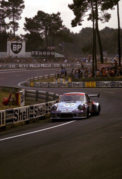 a car driving down a race track with people watching