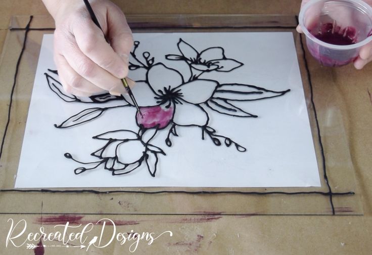 a person is drawing flowers on a piece of paper