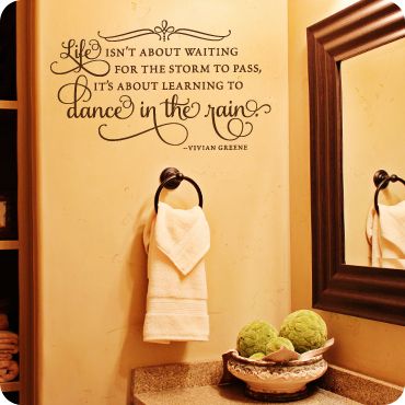 a bathroom with a sink, mirror and wall decal that says don't about waiting for the storm to pass