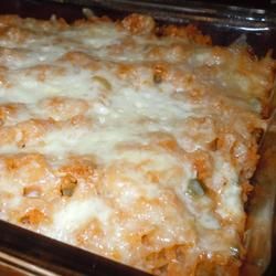 a casserole dish with cheese and meat in it sitting on a baking pan