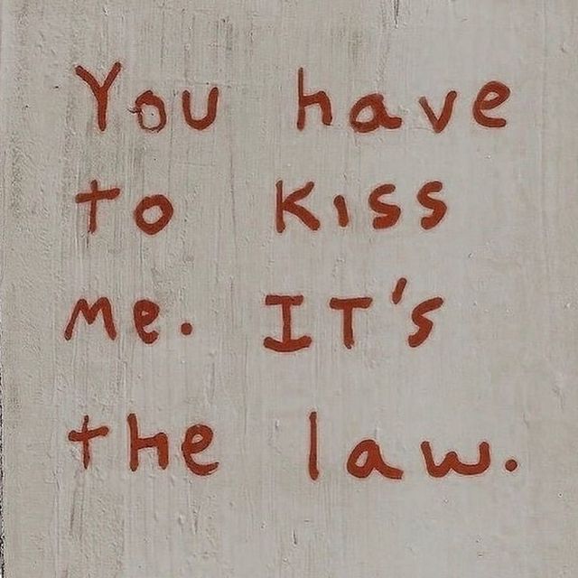 graffiti written on the side of a building that says you have to kiss me it's the law