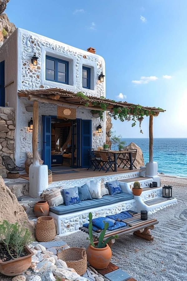 an outdoor living area with couches and potted plants next to the water's edge