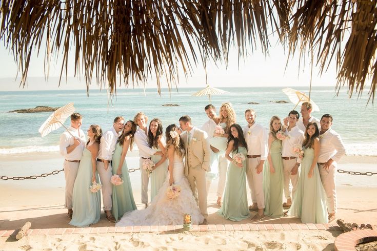 a group of people standing next to each other on a beach