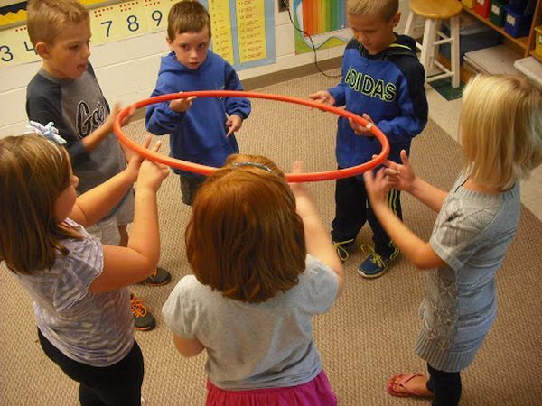 several children are playing with a hula hoop