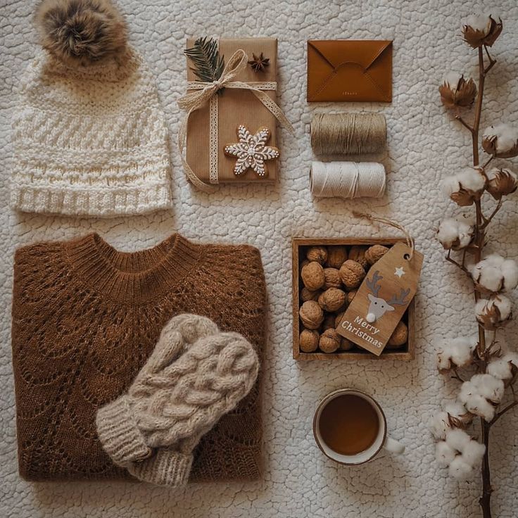 various items are laid out on the floor next to each other, including a sweater, hat, and mug