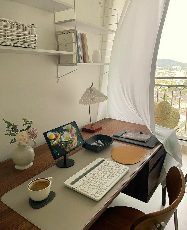 a desk with a computer, keyboard and mouse on it in front of a window