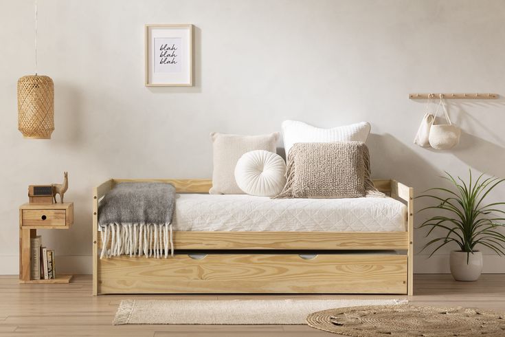 the day bed is made from wood and has two pillows on it, along with other items