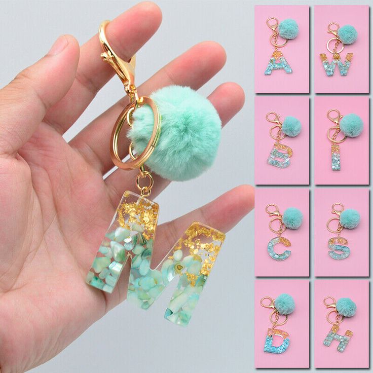 a hand holding a keychain with charms attached to it