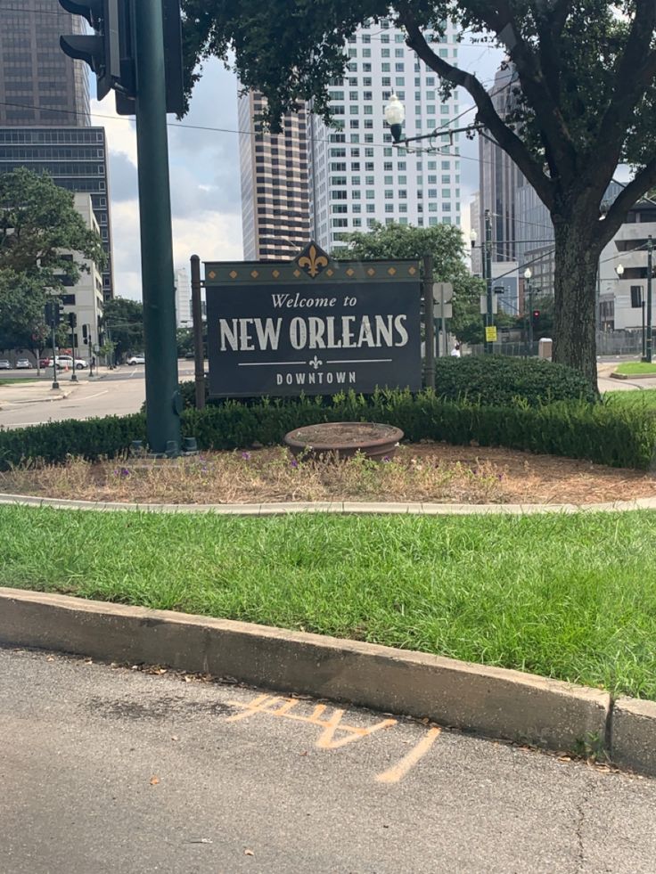 there is a sign that says new orleans on the side of the road in front of some buildings