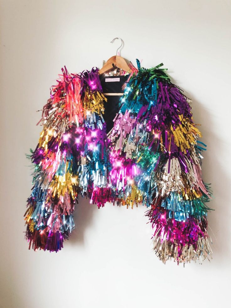 a colorful jacket is hanging on a hanger and it's made out of tinsel