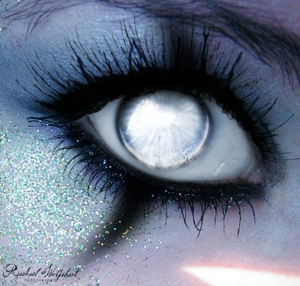 an eye with glitter on it is seen in this artistic photo, which appears to be painted