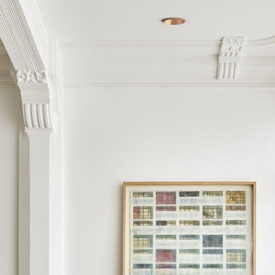 a living room filled with furniture and a painting hanging on the wall above it's fireplace