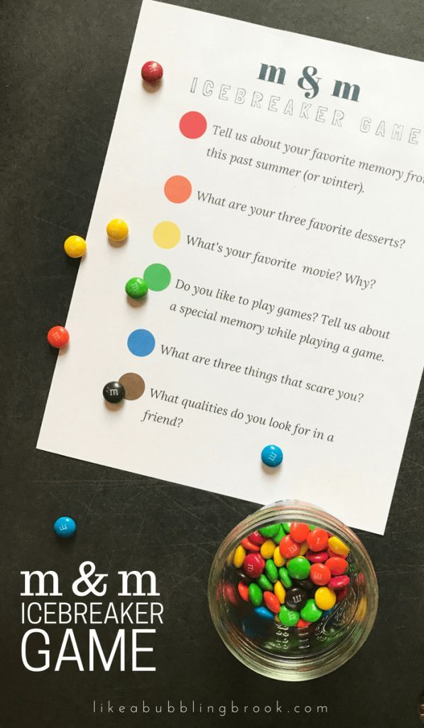 a glass bowl filled with candy sitting on top of a table next to a paper