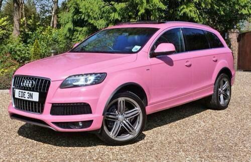 a pink car parked in front of some trees