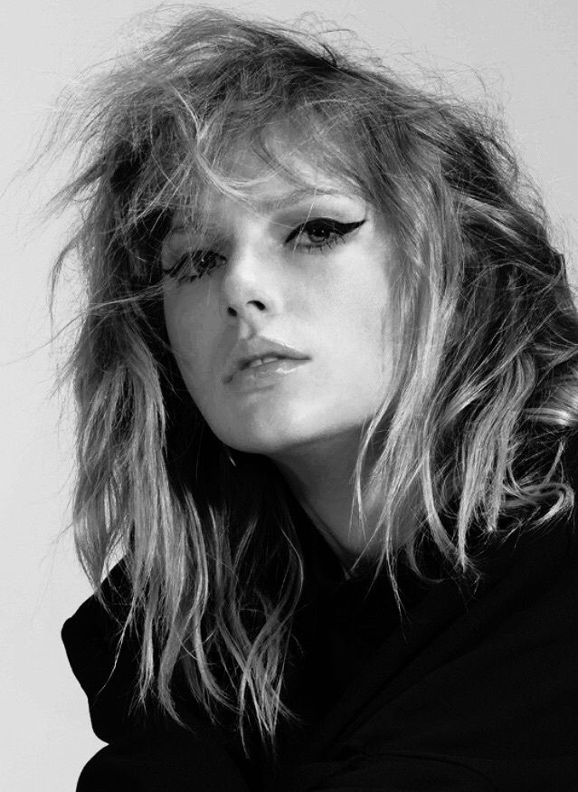 a black and white photo of a woman with her hair blowing in the wind,