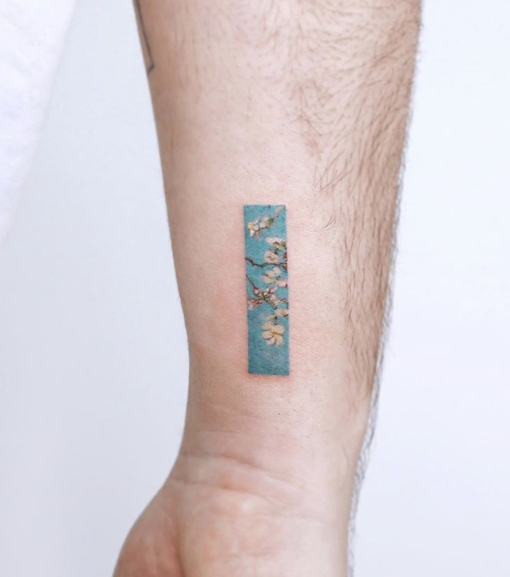 a person's arm with a small tattoo on the left side of their arm