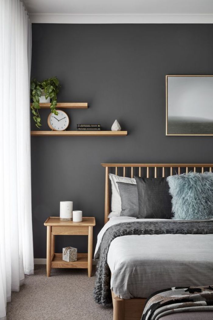 a bedroom with grey walls and white curtains