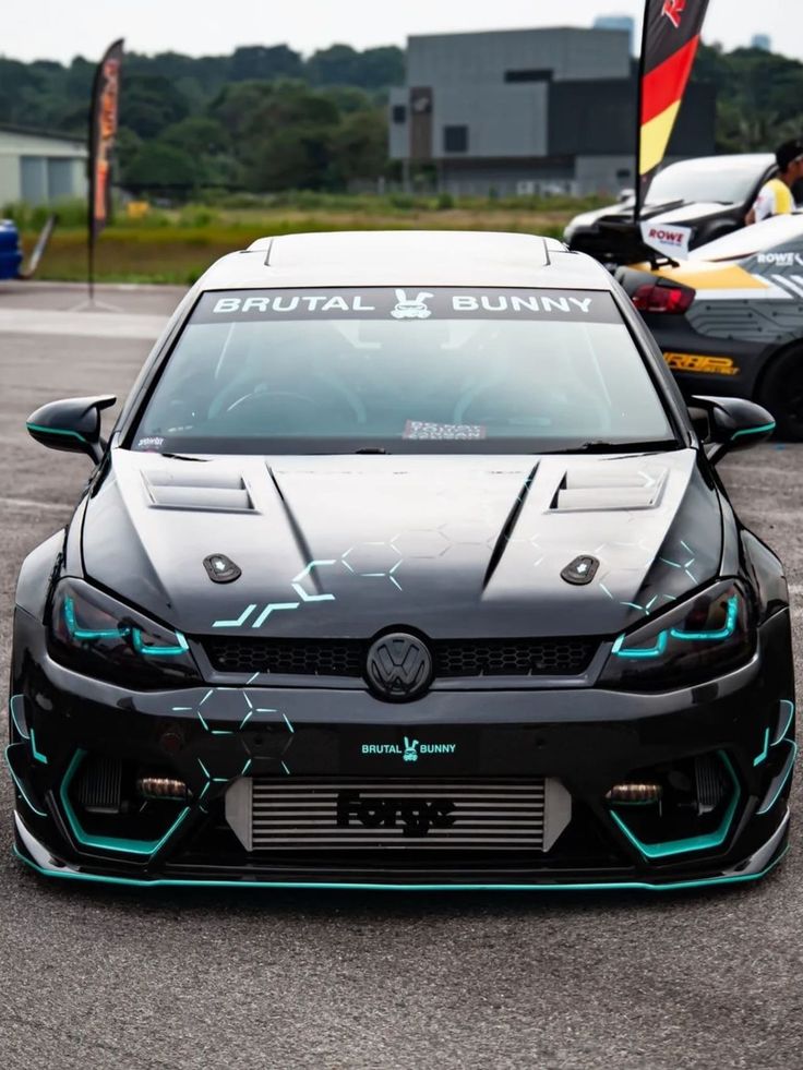 the front end of a black car on a race track