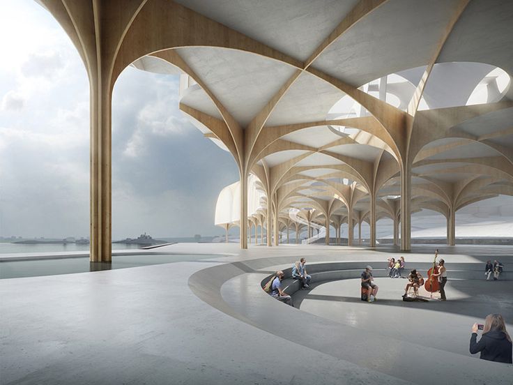 people are sitting and standing in an open area with arches on the ceiling, while one person is taking a photo