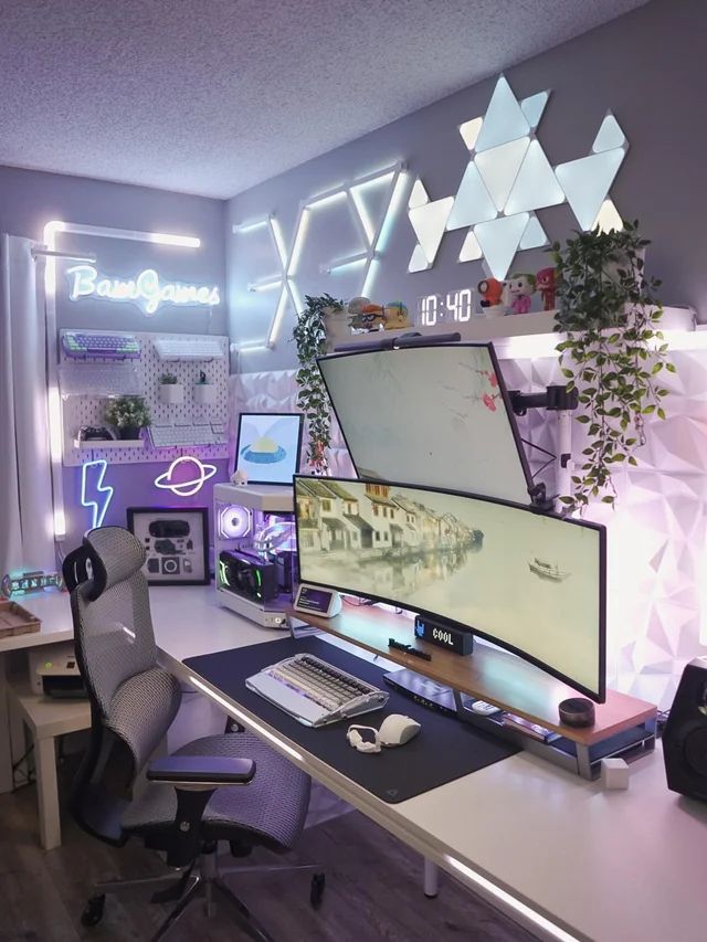 a desk with a computer monitor and keyboard on it in front of a wall mounted plant