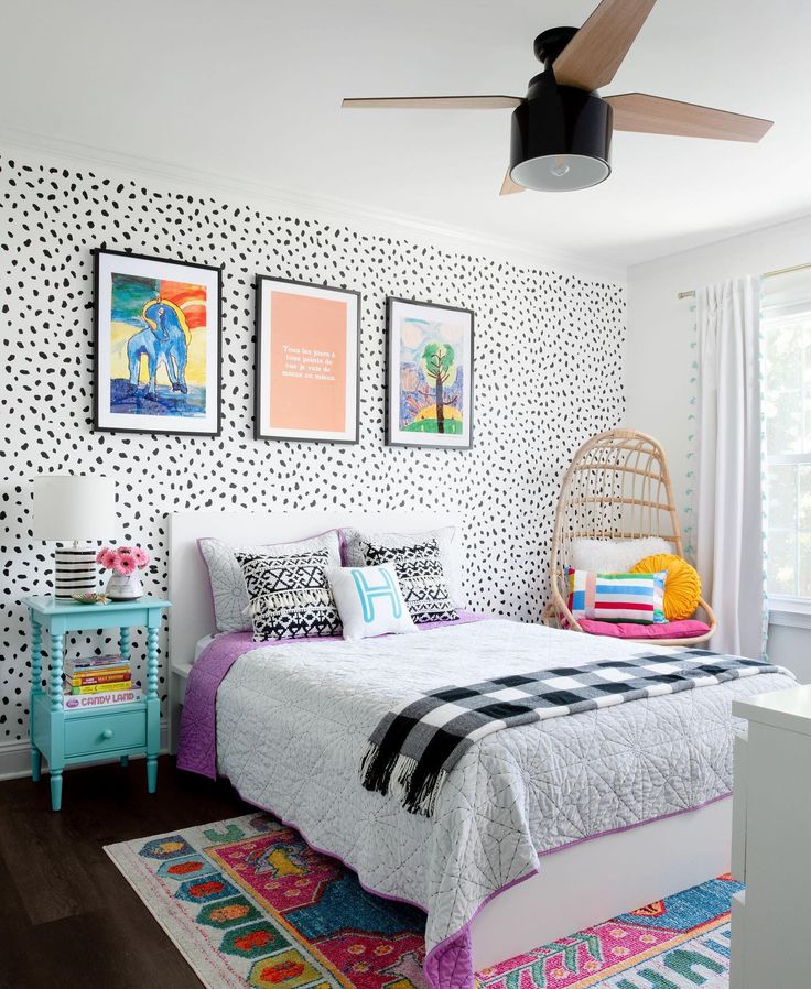 a bed room with a neatly made bed and pictures on the wall