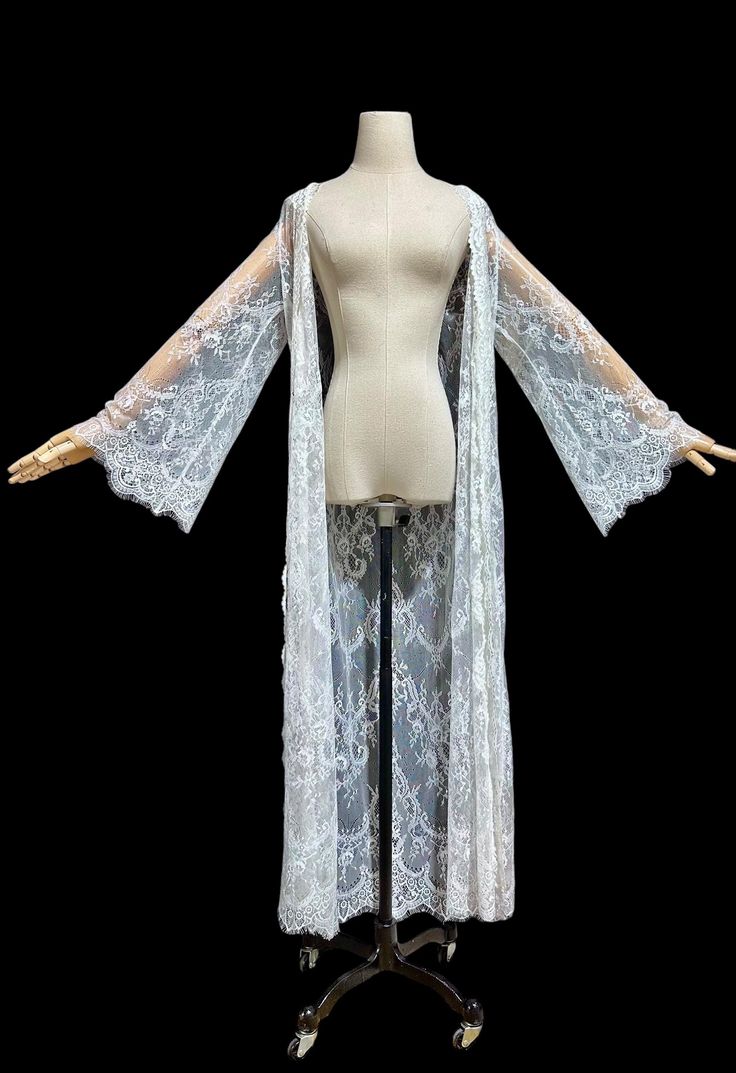 Ethereal sheer white lace dressing gown. Jonquil by Diane Samandi. Romantic and totally sheer dressing gown / dress. Gorgeous feather weight lace is 100% nylon. Just dreamy. Open front with tie sash.  Long bell sleeves. Excellent condition. I don't think it is the original belt. Measures: Variable sizing due to the wrap front. Tagged a size Medium. 16 across the shoulders 40 bust - open front  Cut straight 54 long  . Long Lace Robe For Wedding Night, Sheer Lace Wedding Robe, Lace Wedding Night Robe With Lace Sleeves, Fitted Lace Robe For Wedding Night, White Long Sleeve Party Robe, Sheer Fitted Party Robe, White Lace Trim Robe For Wedding Night, White Robe With Lace Trim For Wedding Night, Long Sleeve Lace Wedding Robe