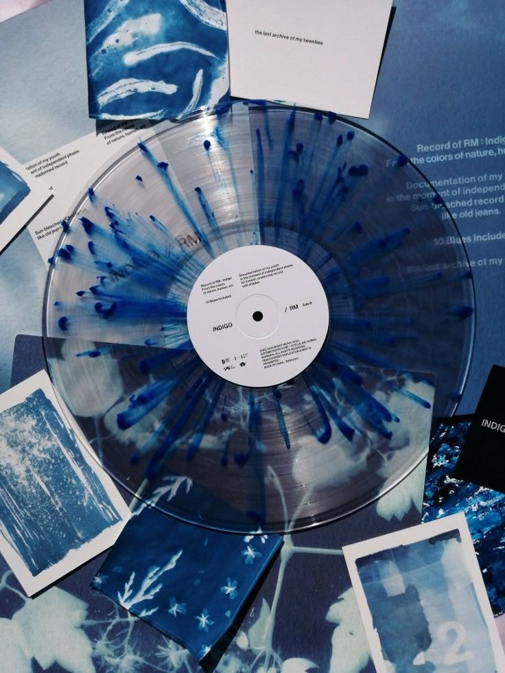 a blue and white swirled vinyl record surrounded by photos