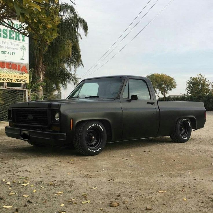 a black pickup truck parked in front of a business sign