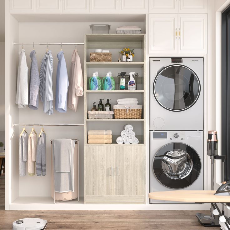 a washer and dryer in a room with white cabinets, wood flooring and open shelving