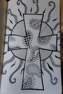 a cross with an octopus on it is drawn in black and white ink, sitting on top of a piece of lined paper