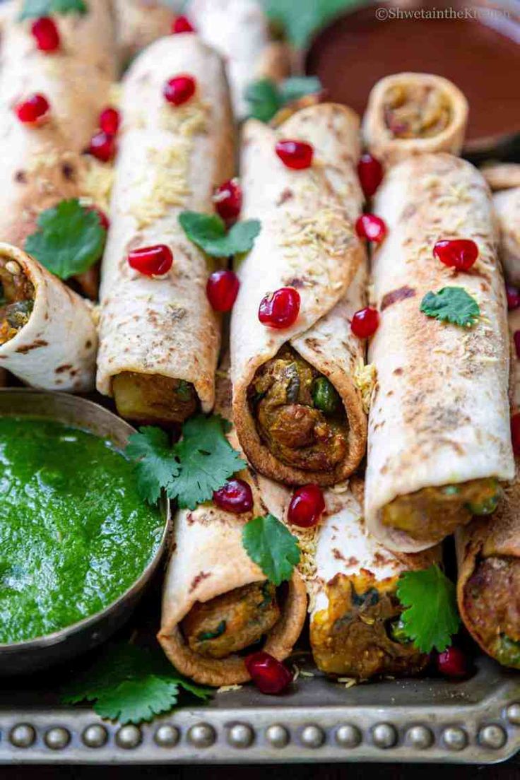 several burritos with salsa and cilantro on a platter