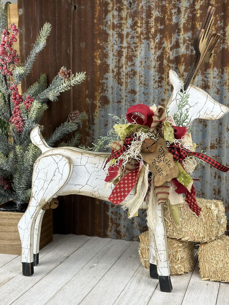 a wooden reindeer decoration sitting on top of hay