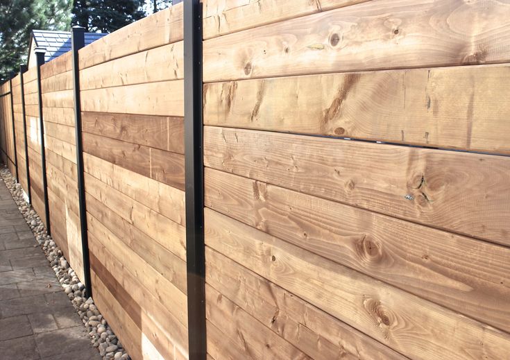 a wooden fence next to a sidewalk