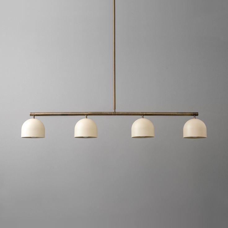 three lights hanging from a ceiling fixture in a room with gray walls and flooring