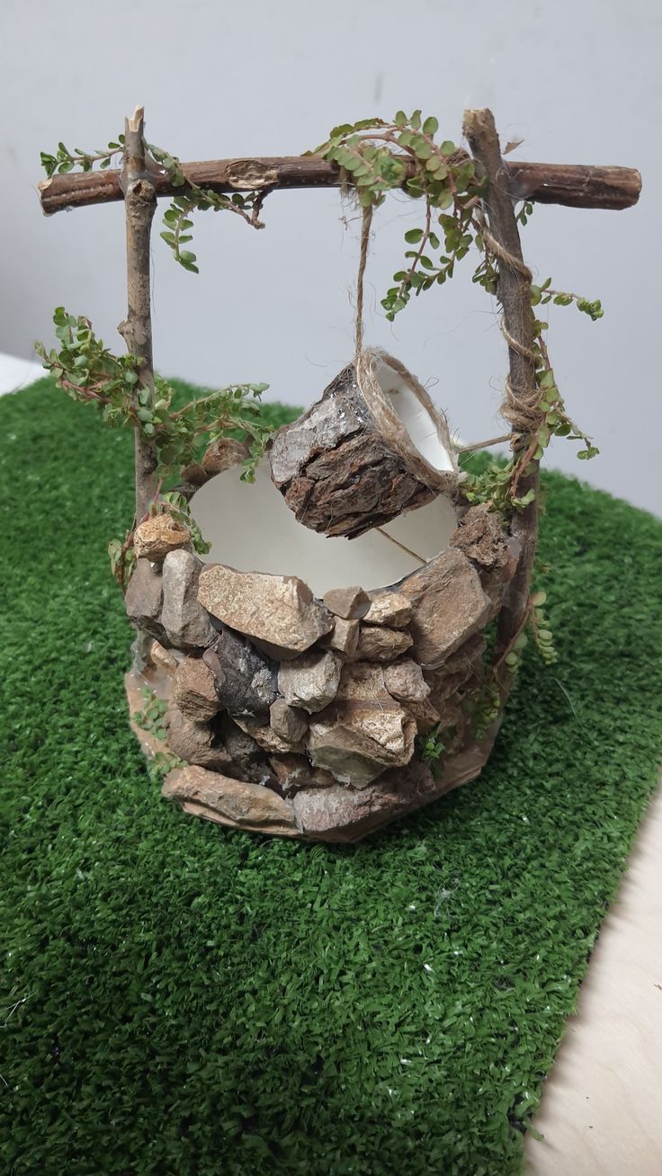 a rock and wood sculpture sitting on top of green grass