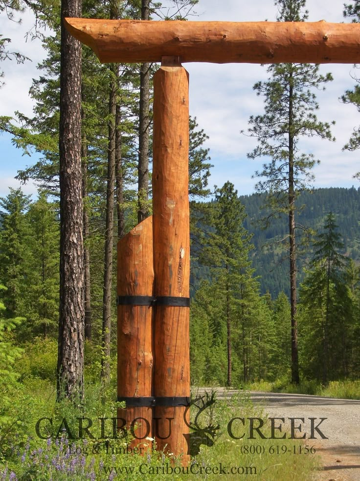 a large wooden structure sitting on the side of a road in front of some trees