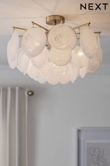 a chandelier hanging from the ceiling in a room with white walls and curtains