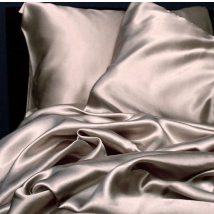 an image of a bed with satin sheets