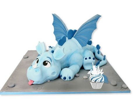 a birthday cake with a blue dragon laying on it