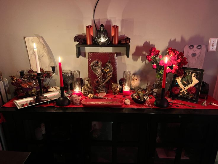 a table topped with candles and pictures on top of it's sides, surrounded by other items