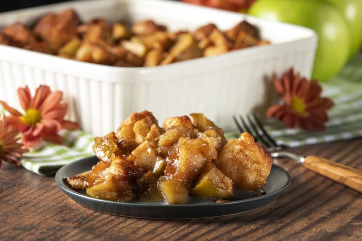 a close up of a plate of food on a table with an apple in the background