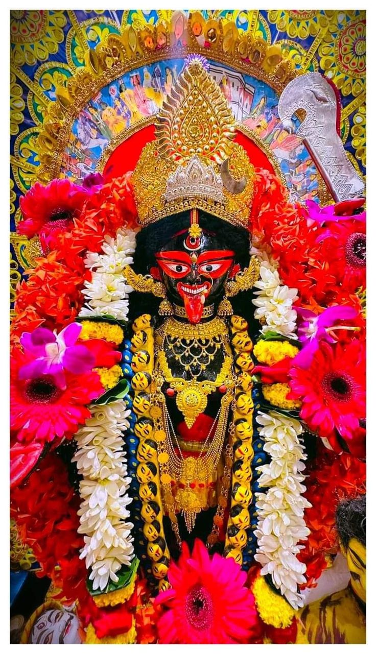 an idol is displayed with flowers in front of it