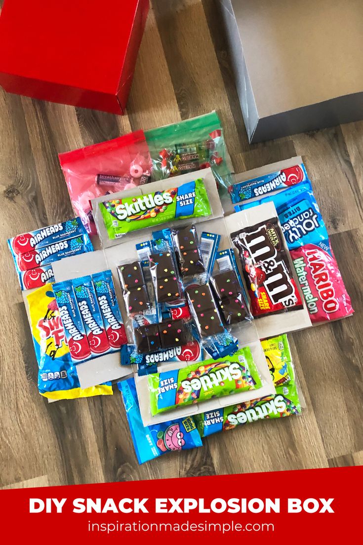 some snacks are laying out on the floor next to a red box with white writing