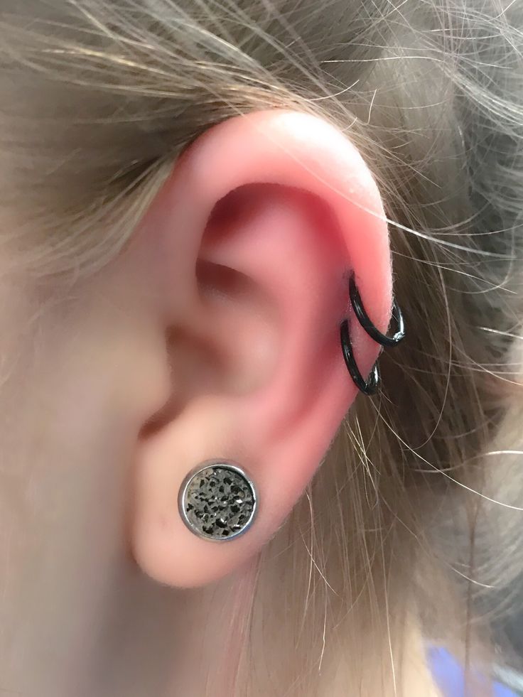 a close up of a person's ear with a metal object in the middle