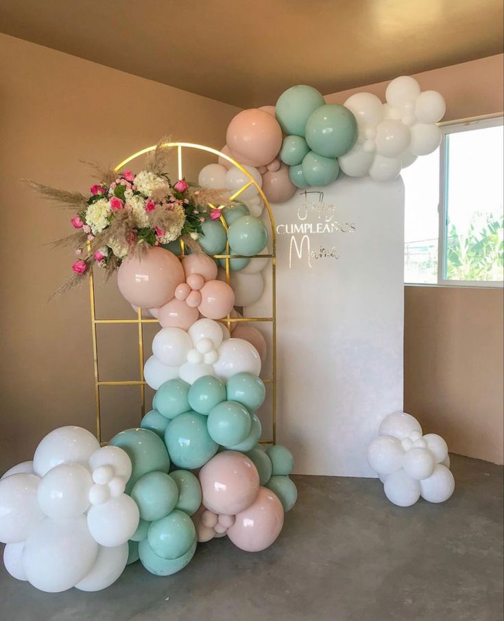 balloon arch with flowers and balloons on it