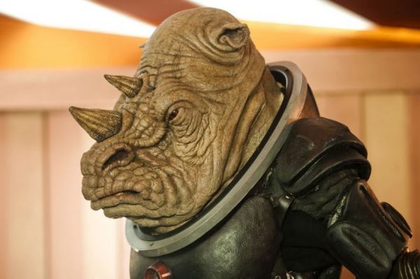 a close up of a statue of an alien wearing a helmet and leather outfit with horns