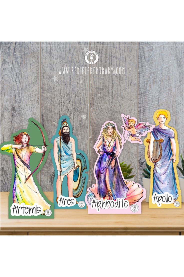 three paper cutouts of jesus and the four graces on a wooden table with plants